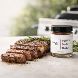 Grilled steak with Lone Star BBQ gourmet spice jar on neutral stone background for the Grill-Worthy spice blends collection by Pinch Dab Dash.